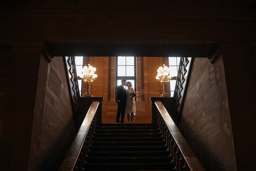 Chwila skradziona na schodach Zamku Cesarskiego w Poznaniu, gdzie para młoda delektuje się wspólnym momentem miłości.