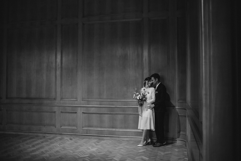 Delikatny uścisk pary młodej w zamkowym holu, ukazujący spokój i miłość w tej historycznej przestrzeni