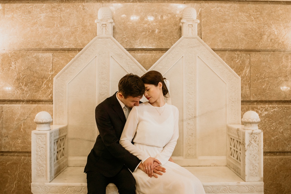 Romantyczny uścisk pary młodej, podkreślający ich związane uczuciem serca w klimatycznych salach Zamku Cesarskiego