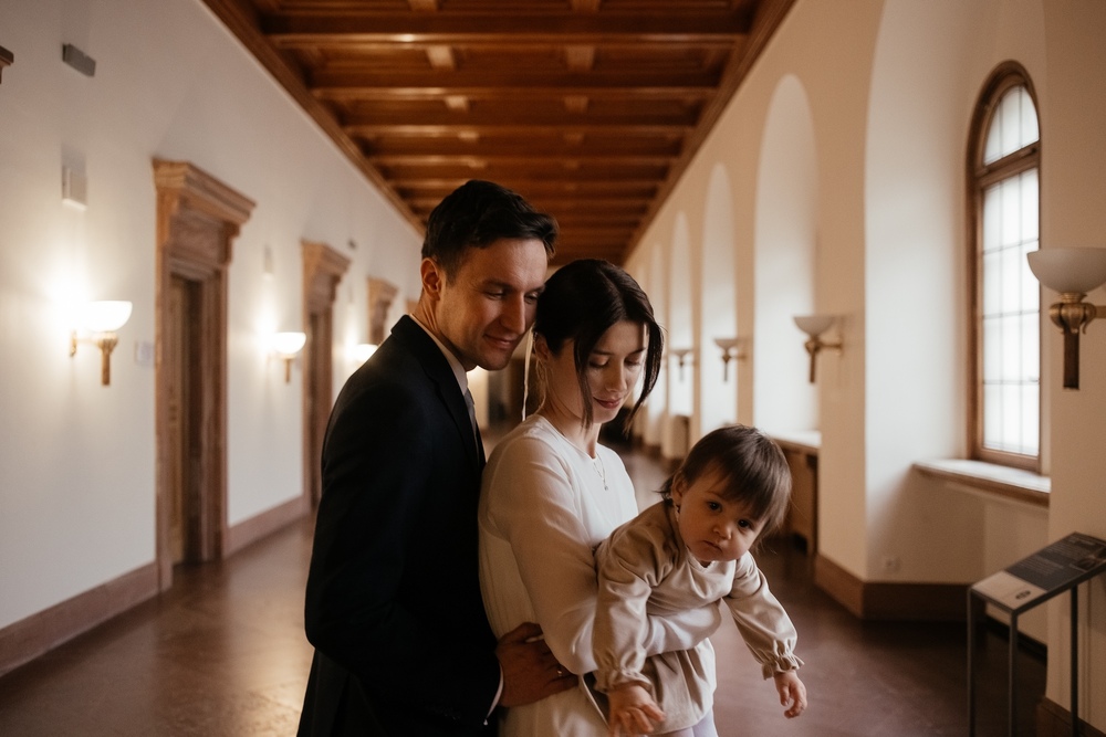 Spontaniczne ujęcia pary młodej z dzieckiem podczas romantycznej sesji plenerowej w otoczeniu Zamku Cesarskiego w Poznaniu
