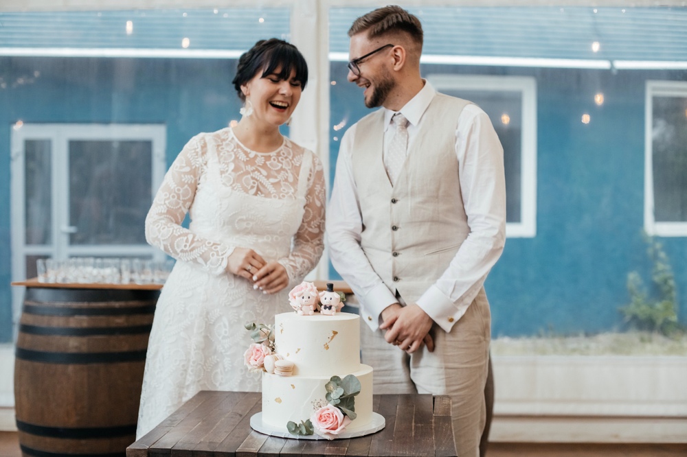 Nowożeńcy w trakcie cięcia weselnego tortu - słodka chwila miłości