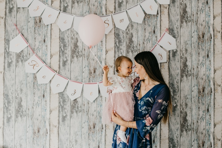 Sesja chrztu Poznań - roczna dziewczynka chwyta tatę za nos