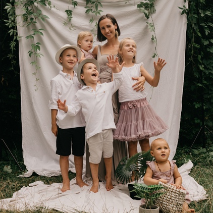 Sesja rodzinna w plenerze Poznań - mama z pięciorgiem dzieci w ogrodzie na białym tle