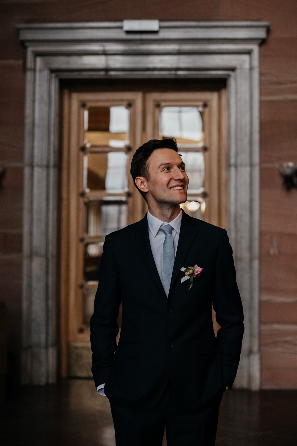 Pan młody delikatnie uśmiecha się do panny młodej w promieniach słońca